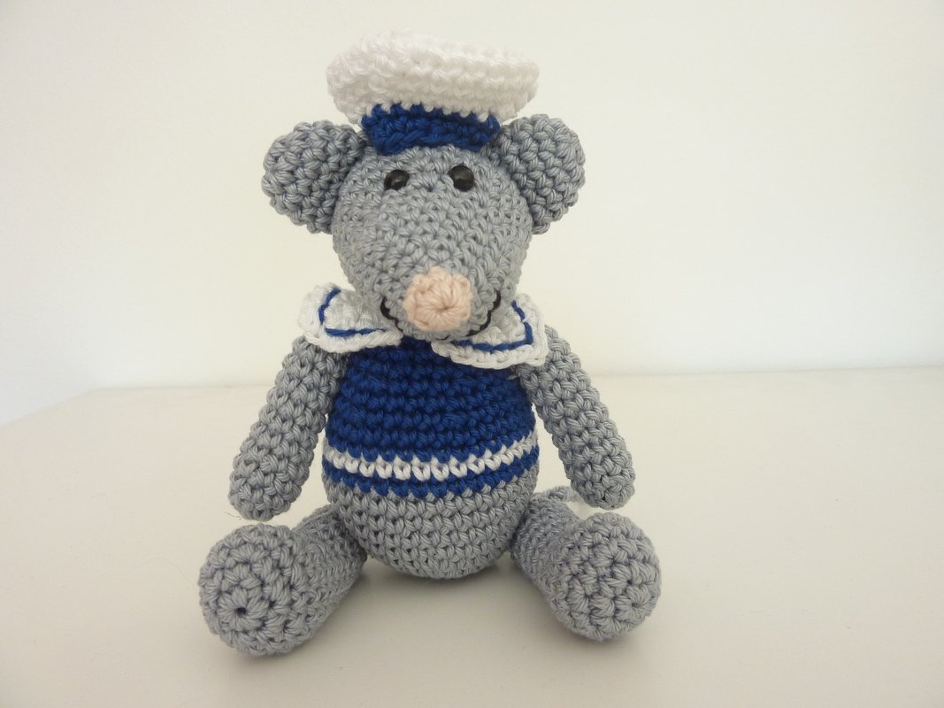 Gehäkelte graue Amigurumi‑Maus mit blau‑weißem Matrosenoutfit, sitzend
