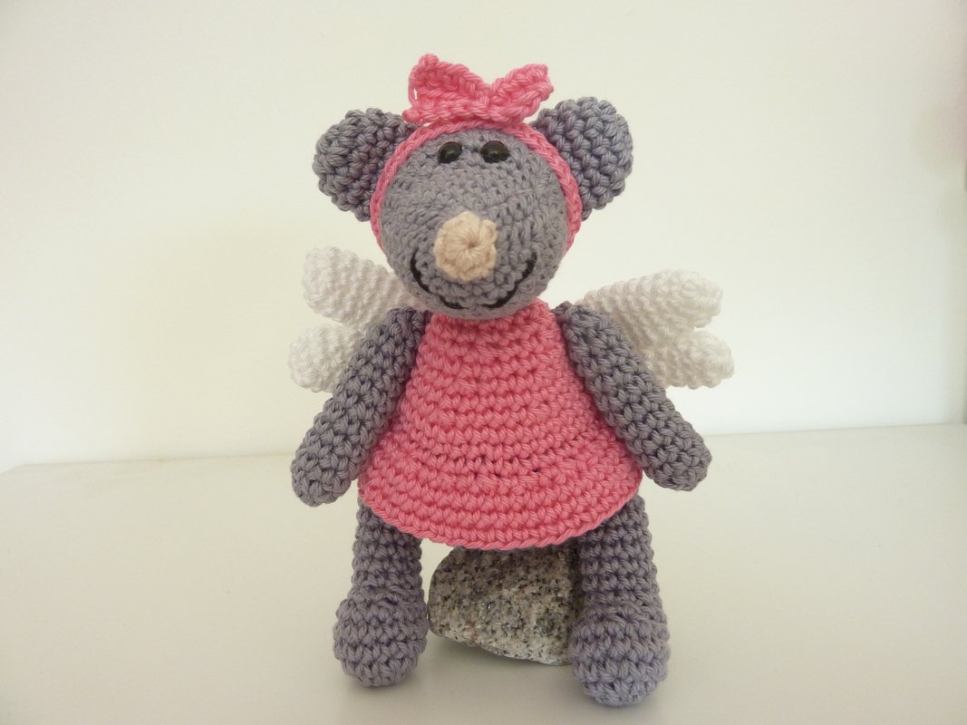 Grau-rosa gehäkelte Amigurumi‑Maus mit weißen Flügeln, rosa Kleid und Schleife