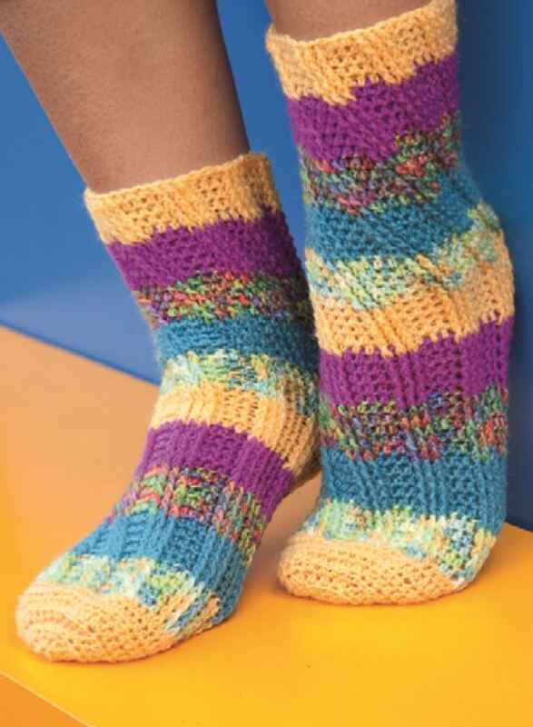 Nahaufnahme gehäkelter Damensocken mit horizontalen Streifen in Gelb, Lila und Türkis