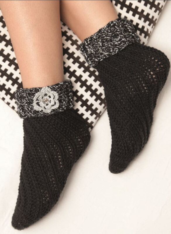 Schwarze gehäkelte Damensocken mit umgeschlagenem schwarz-weißem Bündchen und Häkelblüte