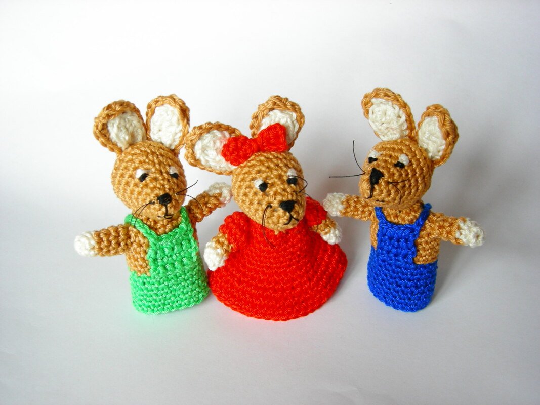 Drei gehäkelte Hasen-Fingerpuppen nebeneinander in grün, rot und blau