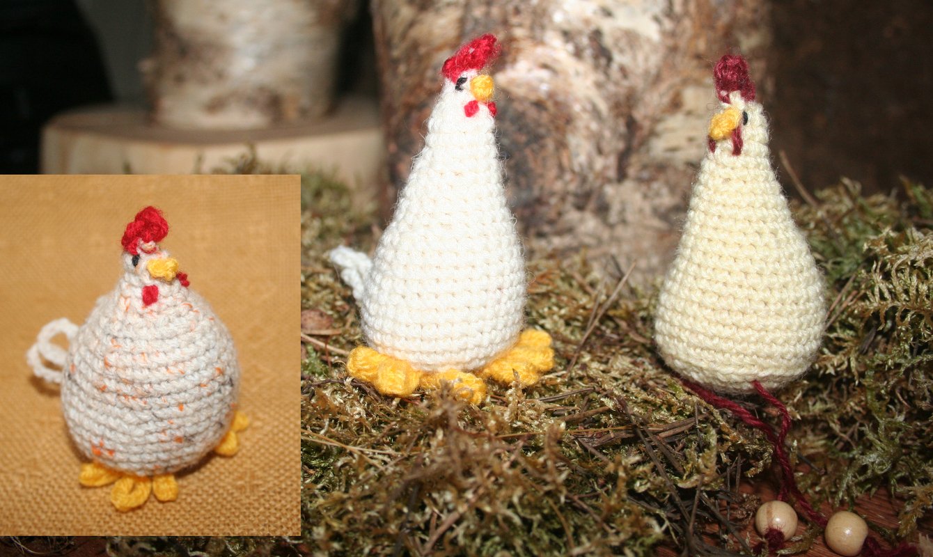 Mehrere kleine gehäkelte Amigurumi-Hühner in Creme mit roten Kämmen und gelben Füßchen auf Moos und Holz