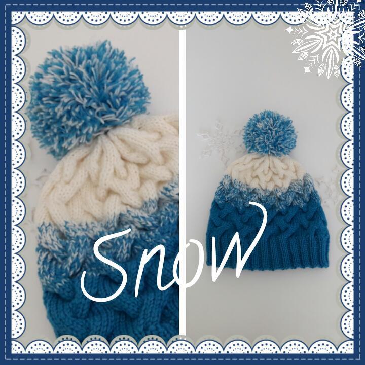 Blau-creme gestrickte Damenmütze mit Zopfmuster und zweifarbigen Bommel