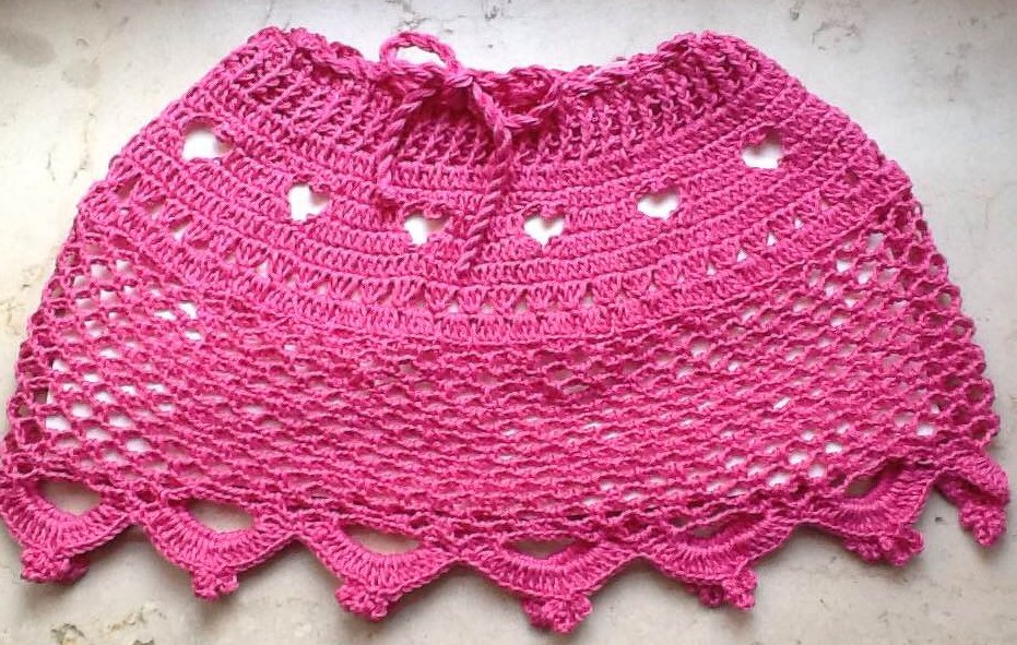 Pink gehäkelter Kinderrock mit Kordelbund, Herzlochmuster und Muschelsaum