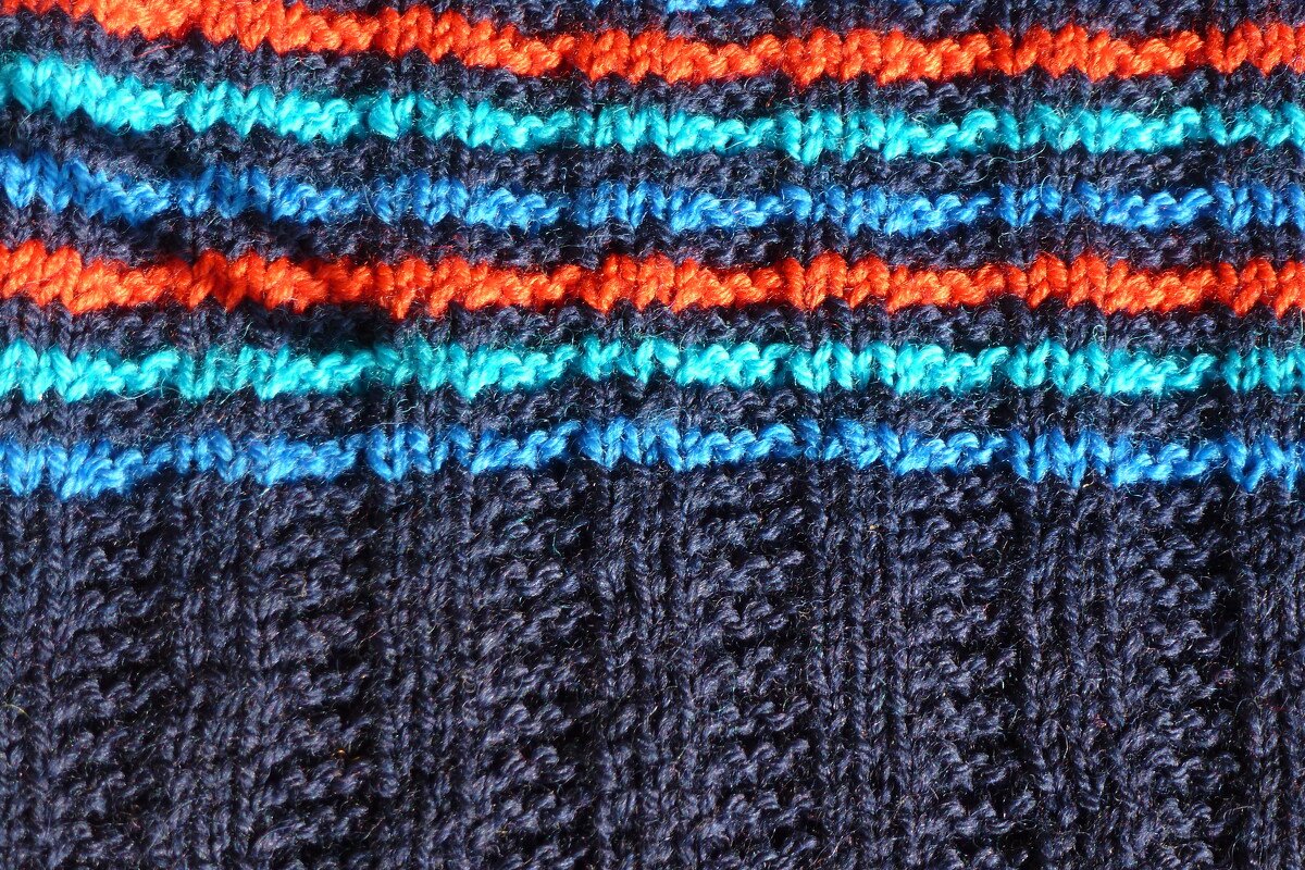 Gestrickter Stoff mit horizontalen Streifen in dunkelblau, orange, türkis und hellblau