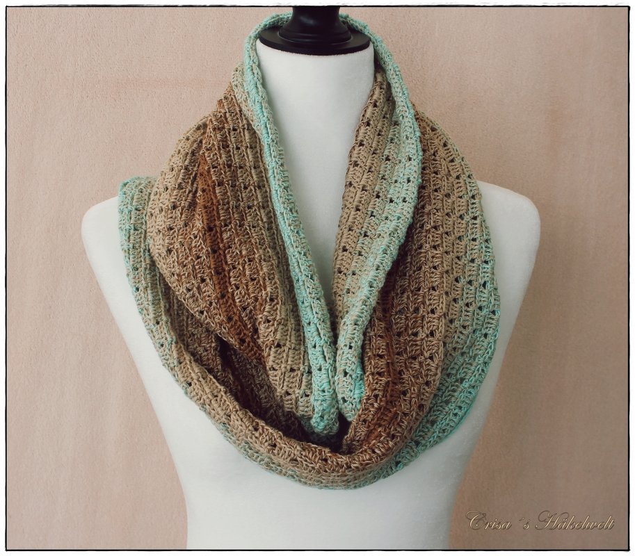 Gehäkelter Loop-Schal mit Türkis-Braunem Farbverlauf auf Schneiderpuppe, offenes Maschenmuster.