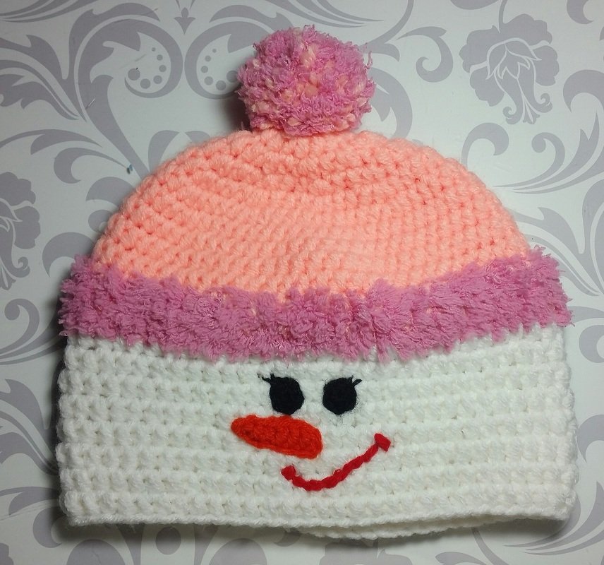 Häkelmütze für Baby oder Kleinkind in Weiß und Rosa mit Bommel und Schneemann‑Motiv