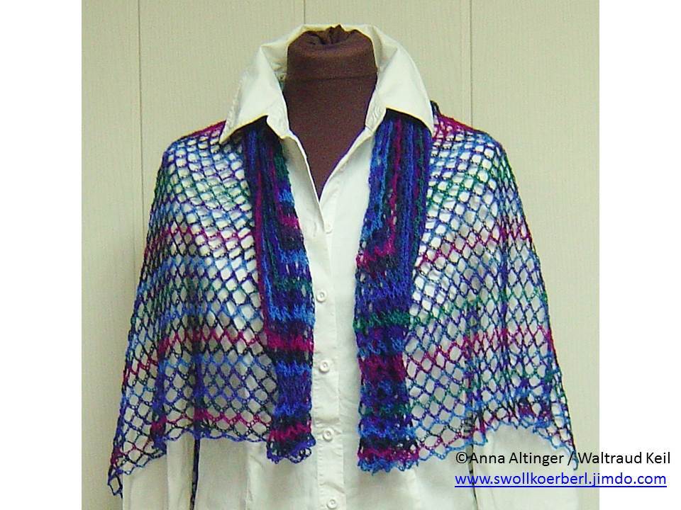 Gehäkeltes Netztuch in Blau-, Lila- und Grüntönen über einer weißen Bluse getragen