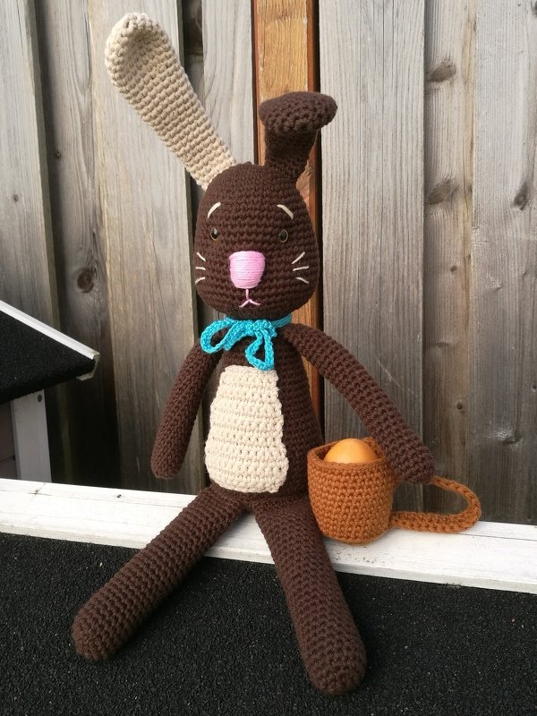 Gehäkelter brauner Hase mit beigem Bauch, rosa Nase und kleinem Korb