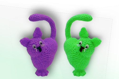 Zwei gehäkelte Amigurumi-Anhänger, einer lila, einer grün, mit Schwanz und Knopfaugen