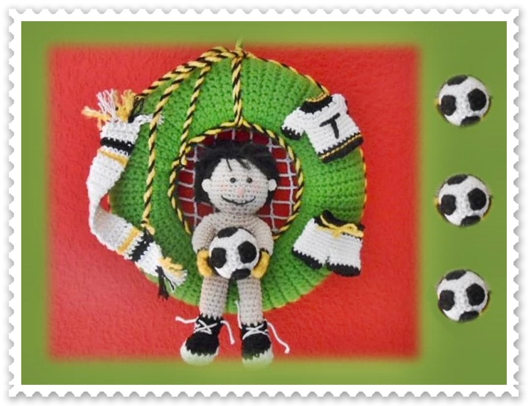 Gehäkelter grüner Türkranz mit sitzendem Häkelspieler und kleinen Fußbällen