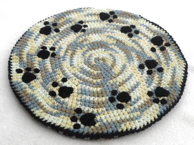 Runder gehäkelter Teppich in Blau‑Grau‑Beige mit schwarzen Pfoten