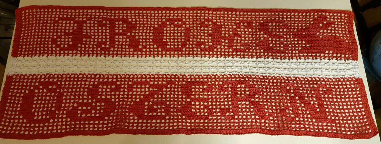 Rot-weißer gehäkelter Tischläufer im Filetmuster mit dem Schriftzug „BRET“ und weißem Mittelstreifen