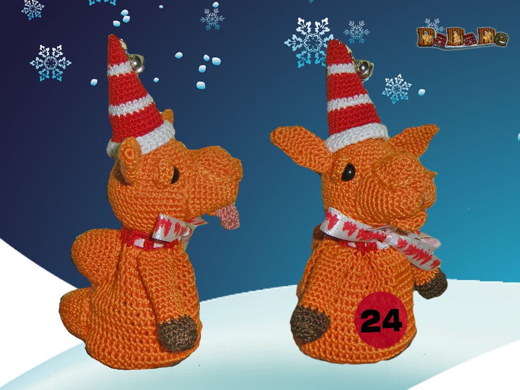 Gehäkelte orangefarbene Drachenfigur mit rot-weiß gestreifter Mütze, Schal, Glöckchen und roter Zahl 24