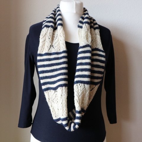 Gestrickter Loop-Schal in dunkelblau und creme mit Streifen und Ajourmuster auf einer Schaufensterpuppe