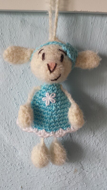 Gehäkeltes weißes Lamm mit hellblauem Kleid und Aufhängeschlaufe