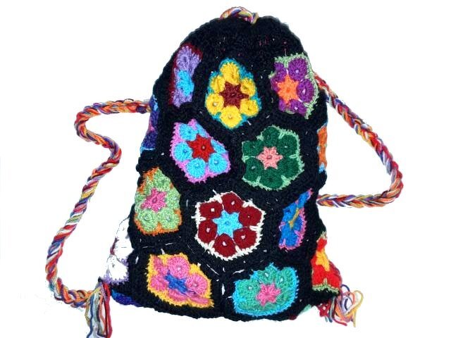 Gehäkelter Rucksack aus bunten African-Flower-Motiven auf schwarzem Grund mit geflochtenen mehrfarbigen Trägern
