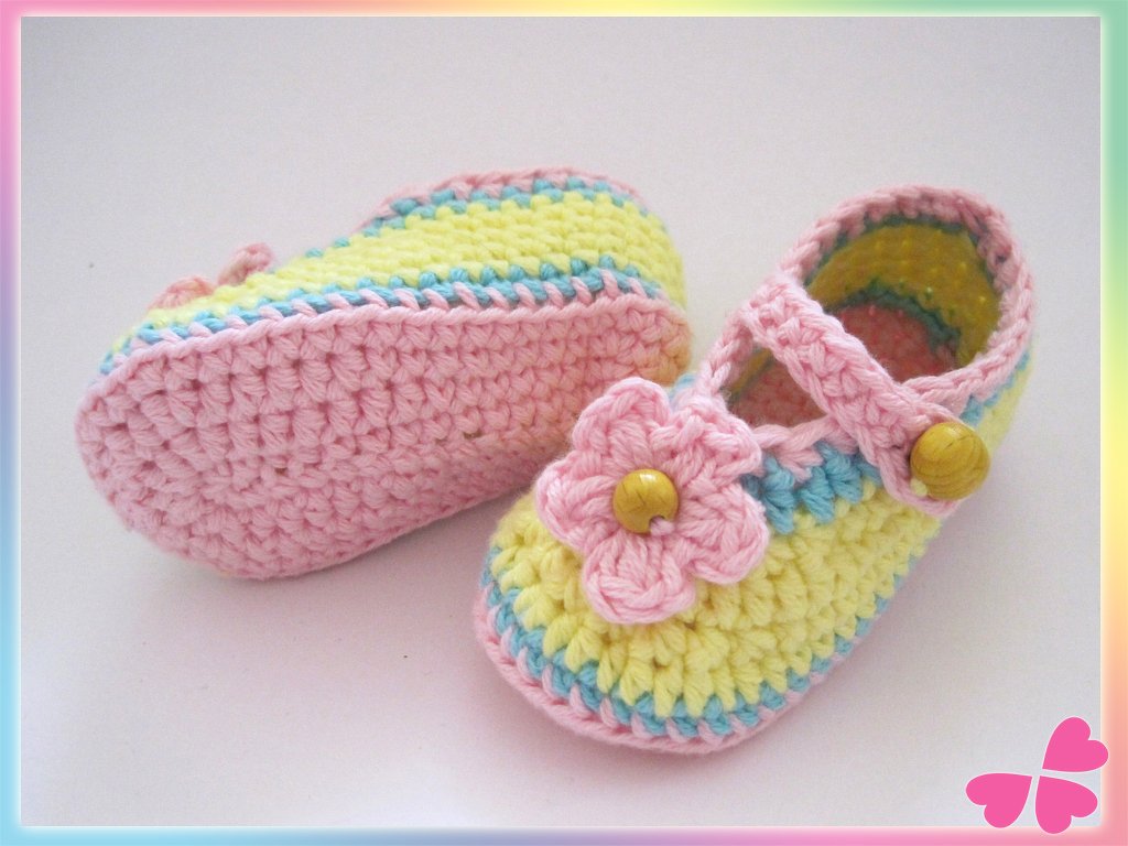 Bunte gehäkelte Baby-Ballerinas mit Blumenverzierung und Riemchen.