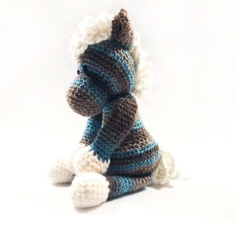 Gehäkeltes gestreiftes Amigurumi in Blau und Braun mit weißer Mähne, seitliche Ansicht