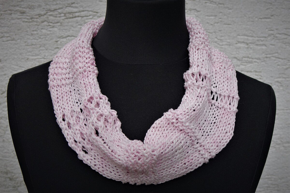 hellrosa gestrickter Loop-Schal mit Lochmuster auf schwarzer Büste
