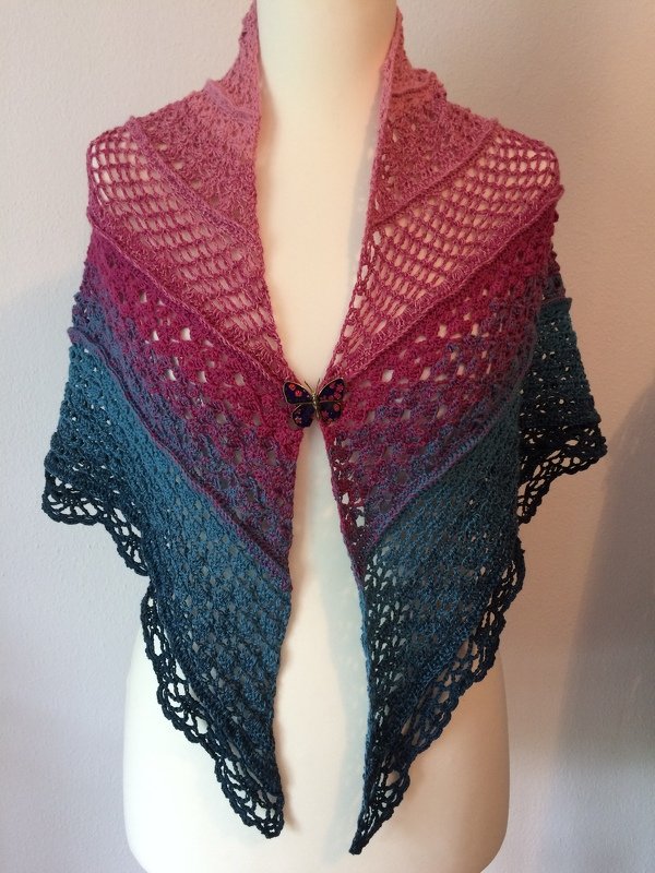 Gehäkeltes Dreieckstuch in Rosa bis Dunkelblau mit Lochmuster, Spitzenkante und Schmetterlingsverschluss auf Schaufensterpuppe