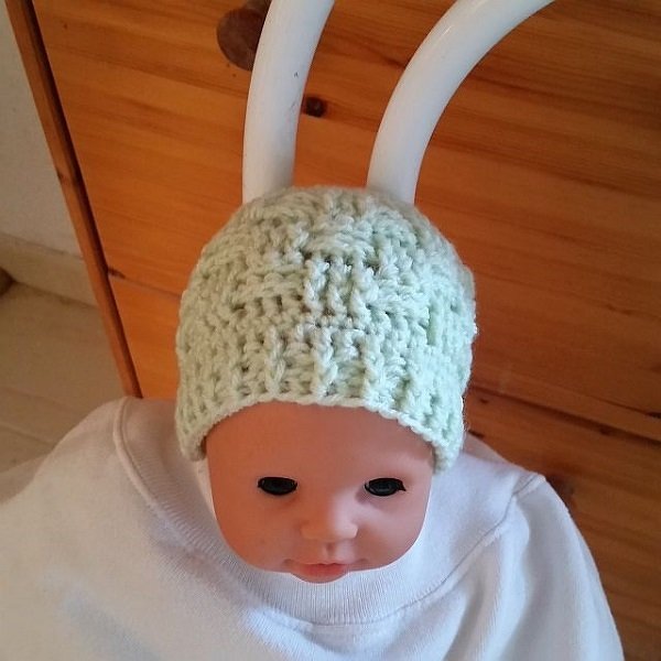 Babypuppe mit hellgrüner, gehäkelter Babymütze