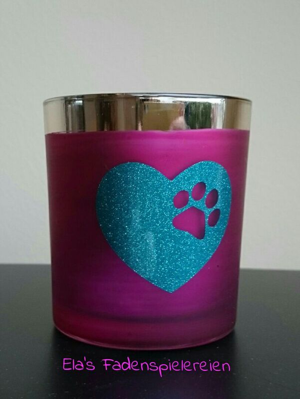 Pinkes Glasgefäß mit türkisfarbenem, glitzerndem Herz und ausgesparter Pfote als Plottmotiv