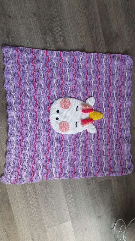 Lila gehäkelte Babydecke mit Wellenmuster und weißer Einhorn-Applikation mit gelbem Horn