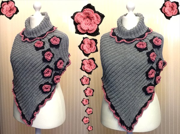 Grauer Strickponcho auf Schaufensterpuppe mit zartrosa-schwarzen Blütenapplikationen und gewelltem Rand