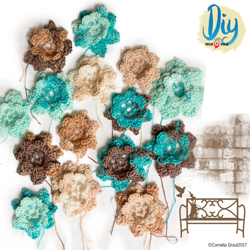 Mehrere gehäkelte Blumenapplikationen in Mint, Türkis, Beige und Braun auf weißem Hintergrund