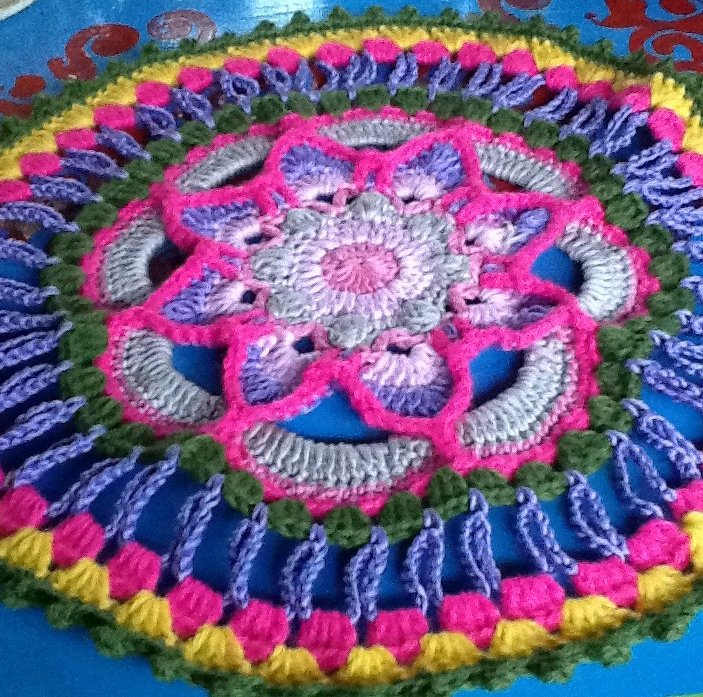 Rundes gehäkeltes Deckchen mit Mandala-Motiv in Pink, Lila, Grün und Gelb