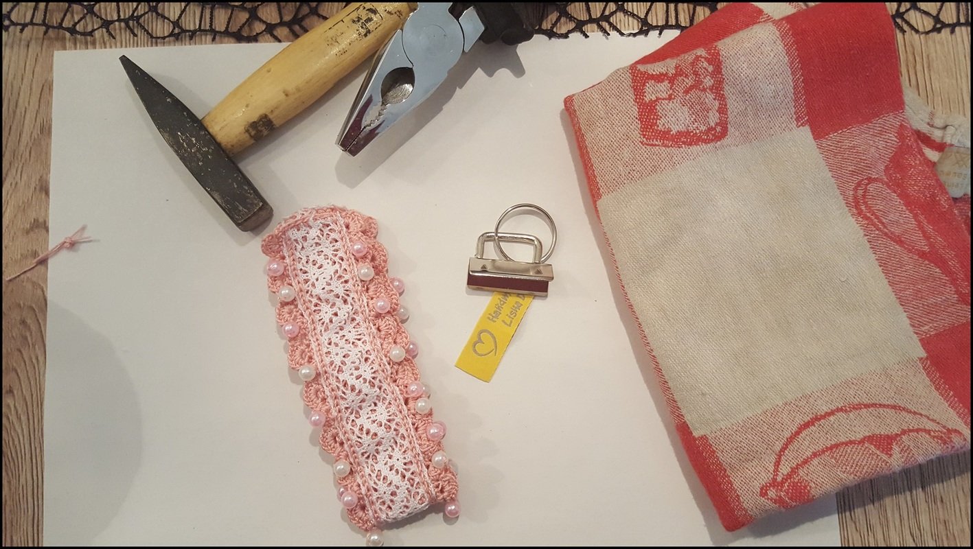 Gehäkeltes Band mit Perlen und Metallklemme neben Zange und Hammer als DIY-Setup