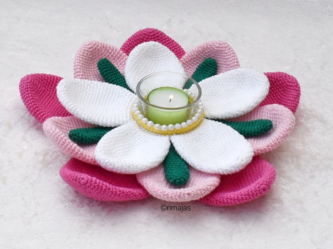 Gehäkelter Blumen-Teelichthalter in Rosa, Weiß und Grün mit brennender Kerze