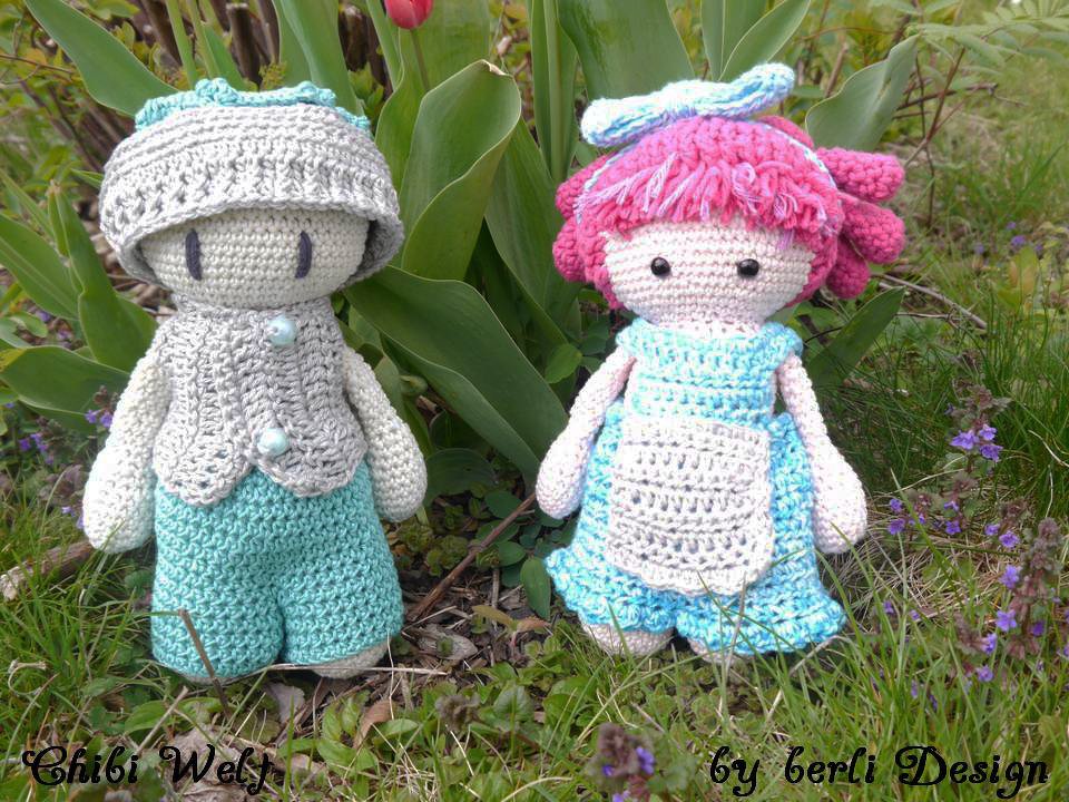 Zwei gehäkelte Amigurumi-Puppen in Türkis und Rosa mit Mütze, Weste und Kleid