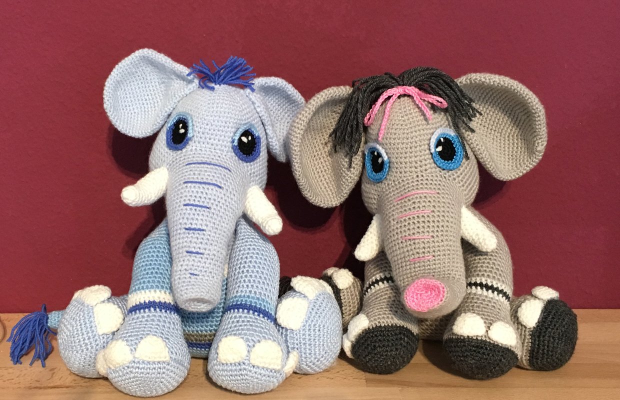 Zwei gehäkelte Amigurumi-Elefanten in Hellblau und Grau, detailliert dargestellt.