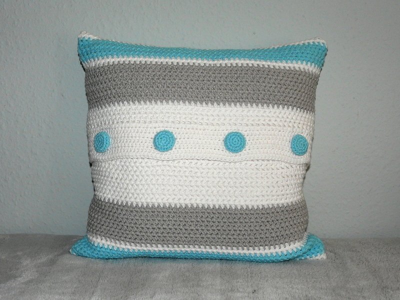 Quadratisches gehäkeltes Kissen mit grauen und weißen Streifen und vier türkisen Punkten