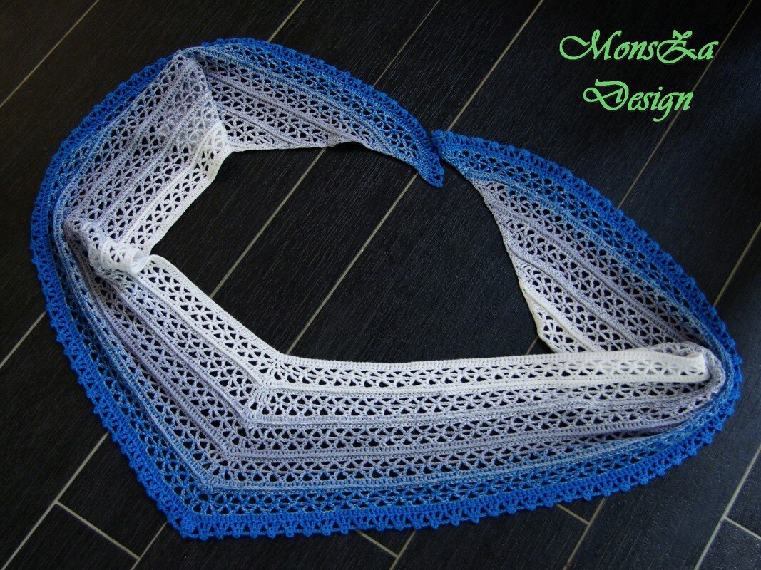 Blau-weißes gehäkeltes Dreieckstuch mit Lochmuster und Zierkante auf dunklem Boden