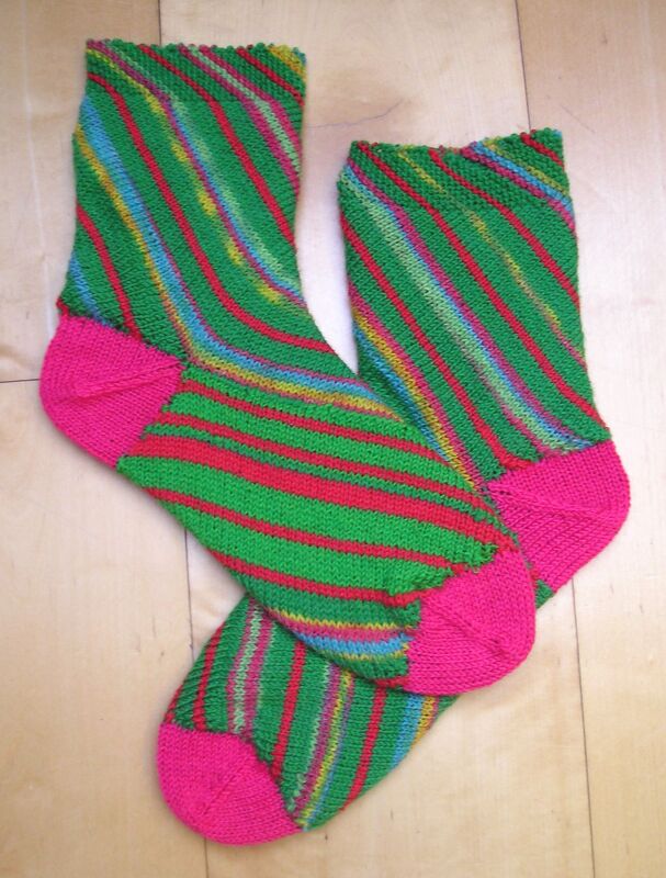 Bunte handgestrickte Socken mit diagonalen Streifen, pinker Ferse und Spitze