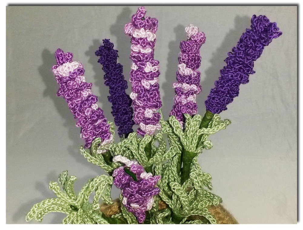 Gehäkelter Lavendelstrauß mit lila Blüten und grünen Blättern in einem Topf