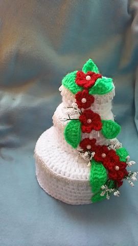 Dreistöckige gehäkelte Hochzeitstorte in Weiß mit roten Blüten und grünen Blättern