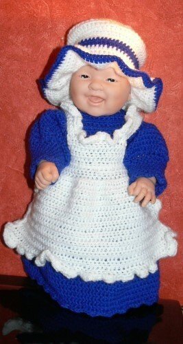 Puppe in gehäkeltem blauem Kleid, weißer Schürze und weiß-blauer Haube