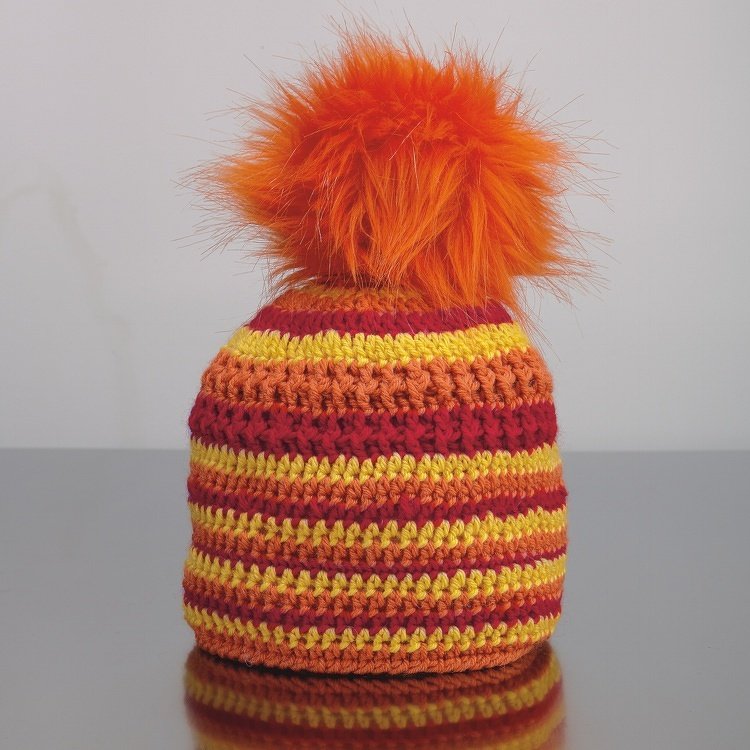 Gehäkelte Kinder-Mütze mit gelb-orange-roten Streifen und orangefarbenem Bommel
