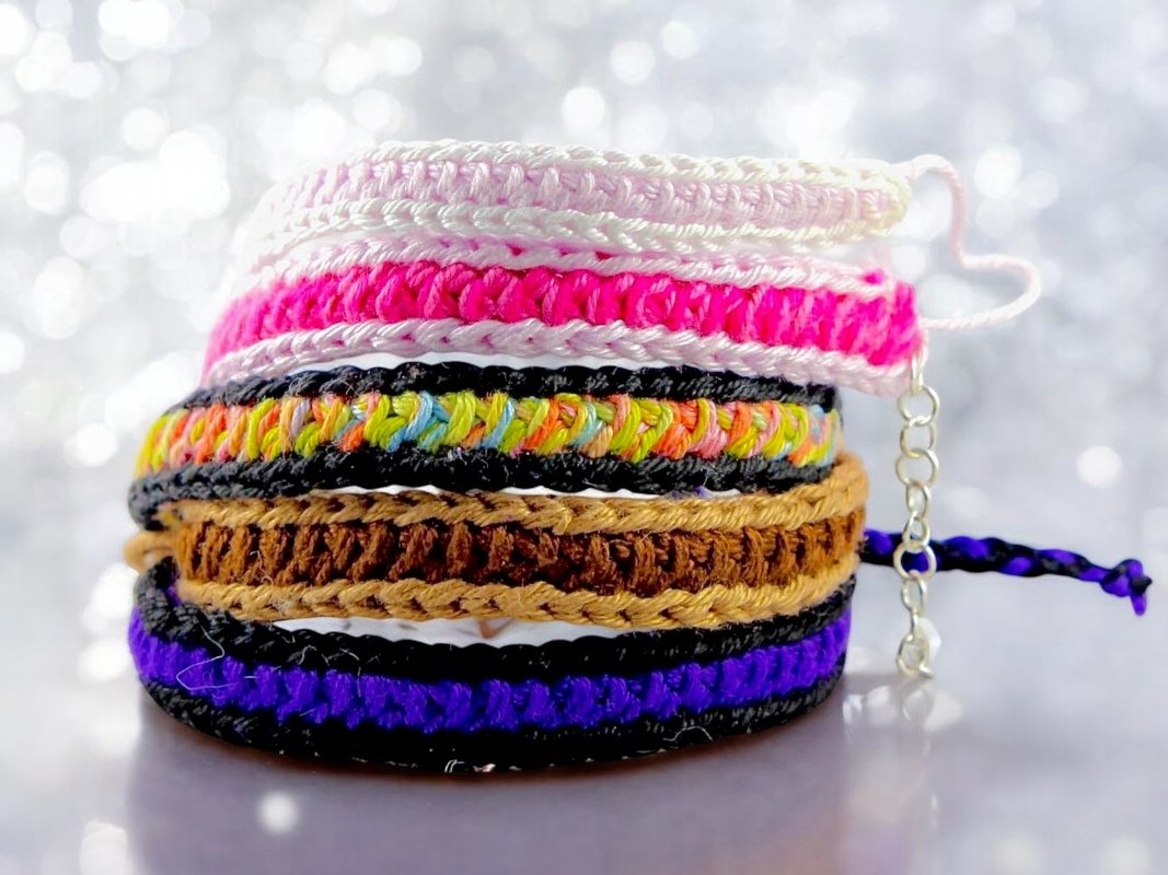 Stack of colorful crochet bracelets with metal extension chain and braided tie