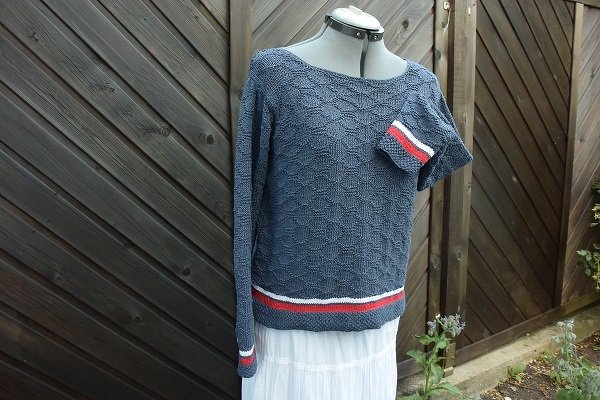 Dunkelblauer Strickpullover mit Strukturmuster und rot-weißen Streifen an Saum und Ärmelbündchen auf Schneiderpuppe