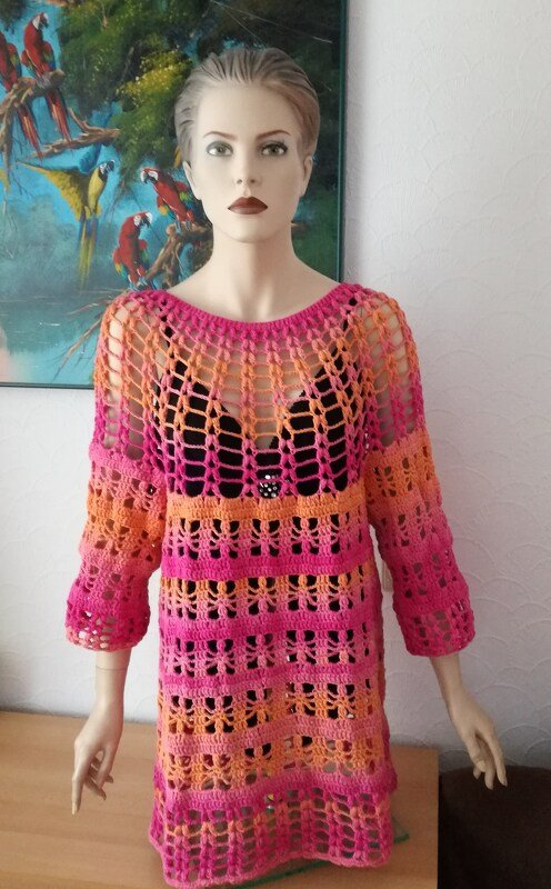 Mannequin trägt gehäkelte Damen-Tunika in Pink-Orange mit Ajourstreifen und Dreiviertelärmeln