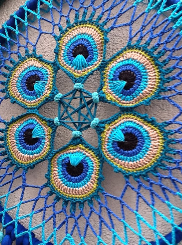 Nahaufnahme eines gehäkelten Traumfängers mit sechs Pfauenaugen-Mandalas in Blau- und Türkistönen