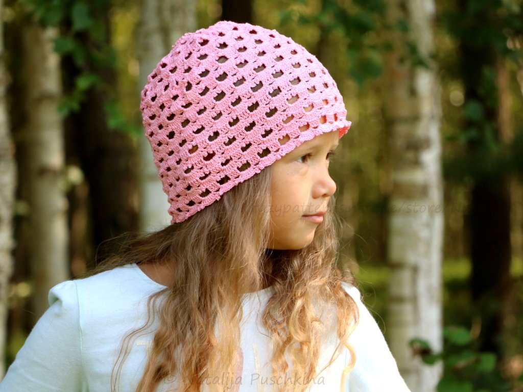 Seitenansicht einer rosa Häkelmütze mit regelmäßigem Lochstich auf Kindskopf