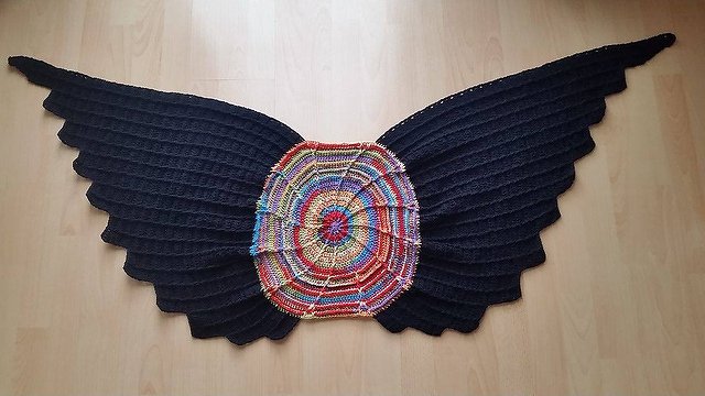 Gehäkeltes schwarz-buntes Flügeltuch mit rundem, mehrfarbigem Mittelteil und gezackten Seitenkanten