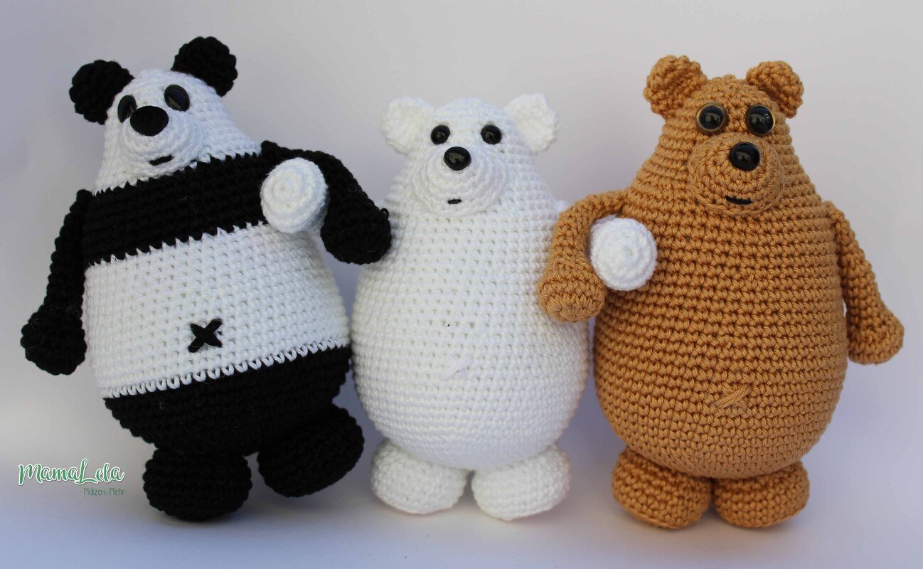 Drei gehäkelte Amigurumi-Bären nebeneinander: Panda (schwarz-weiß), Eisbär (weiß) und Braunbär (braun) vor hellem Hintergrund.