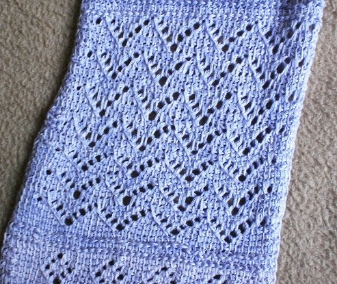 Nahaufnahme eines hellvioletten gehäkelten Schals mit Rautenmuster